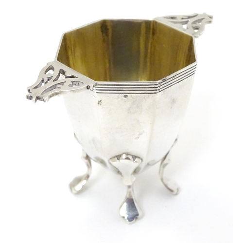 173 - A silver octagonal formed salt / pepper base with twin handles and gilded interior. Hallmarked Londo... 