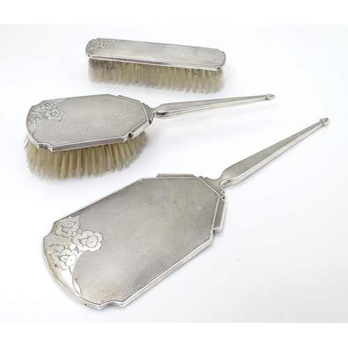 203 - A three piece silver dressing table set comprising 2 brushes and a hand mirror all with engine turne... 