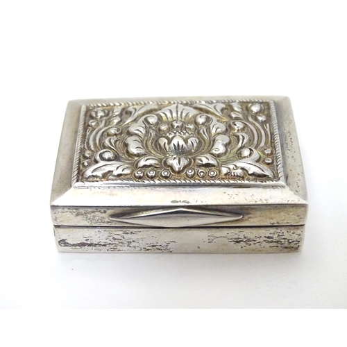 204 - A white metal box of rectangular form with hinged lid.  1 3/4'' x 1 1/4'' x 3/8''