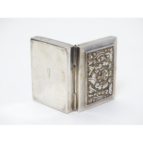 204 - A white metal box of rectangular form with hinged lid.  1 3/4'' x 1 1/4'' x 3/8''