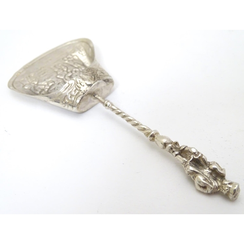 205 - A Continental white metal caddy spoon depicting figures dancing. German . 800 silver 4'' long