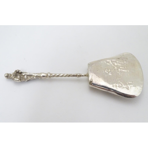 205 - A Continental white metal caddy spoon depicting figures dancing. German . 800 silver 4'' long