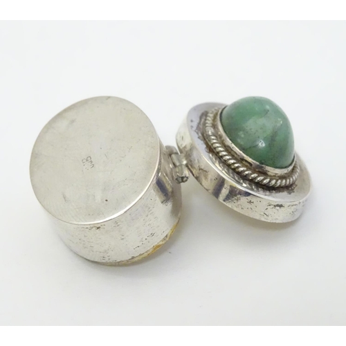 216 - A white metal pill box of oval form with jade cabochon to lid. 1'' wide