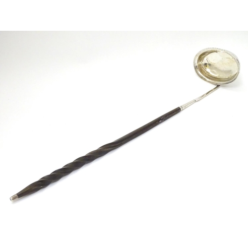 233 - A 19thC  punch / toddy ladle with twist handle and white metal mounts and bowl. Approx 14'' long