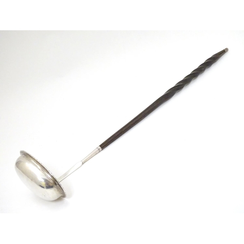 233 - A 19thC  punch / toddy ladle with twist handle and white metal mounts and bowl. Approx 14'' long