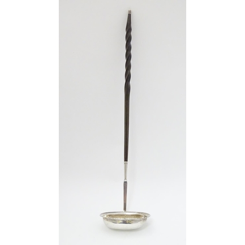 233 - A 19thC  punch / toddy ladle with twist handle and white metal mounts and bowl. Approx 14'' long