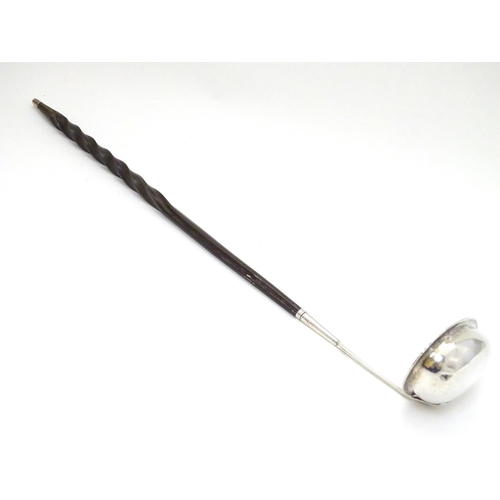 233 - A 19thC  punch / toddy ladle with twist handle and white metal mounts and bowl. Approx 14'' long