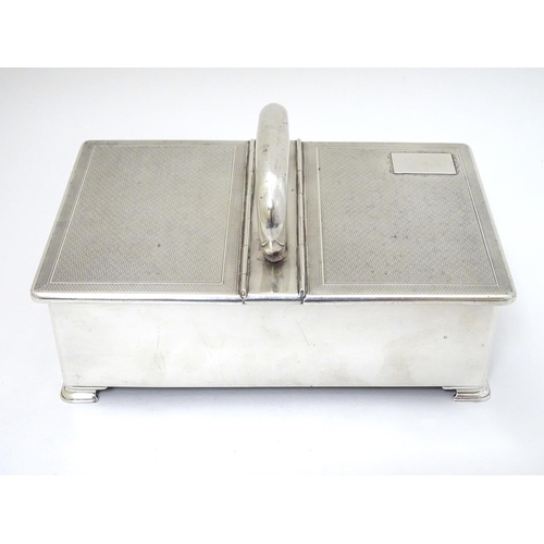 237 - An Art Deco silver table top cigarette box with engine turned decoration, central handle and two hin... 