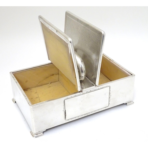 237 - An Art Deco silver table top cigarette box with engine turned decoration, central handle and two hin... 