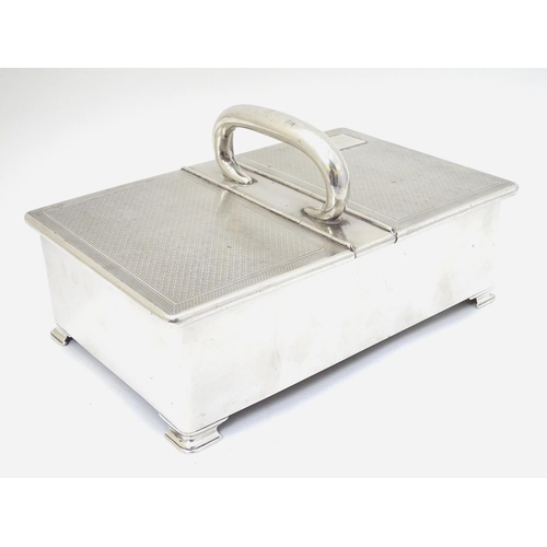 237 - An Art Deco silver table top cigarette box with engine turned decoration, central handle and two hin... 