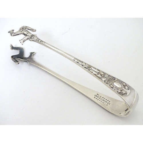 238 - c1901 Silver plated sugar tongs, the grips formed as three running legs ( Isle of Mann emblem) and m... 