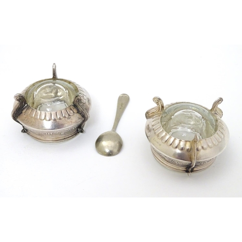 242 - A pair of Continental white metal salts with floral scroll decoration and clear glass liners. approx... 