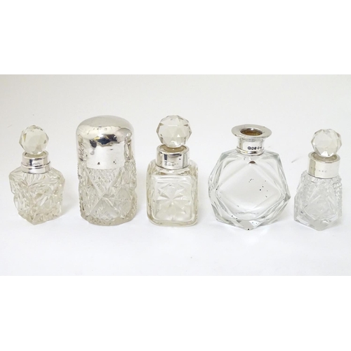 243 - 5 assorted glass scent bottles, some with silver mounts. The tallest 3'' high