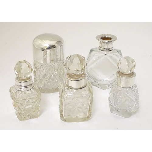 243 - 5 assorted glass scent bottles, some with silver mounts. The tallest 3'' high