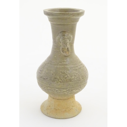 25 - An Oriental earthenware vase with a flared base and rim, and elephant head handles. Approx. 6 ½'' hi... 