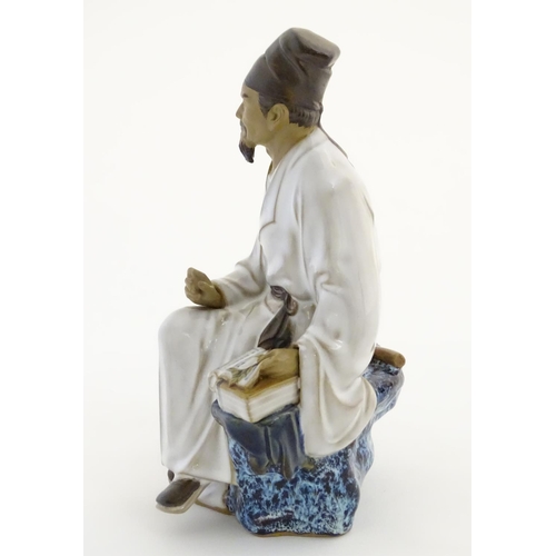 26 - A Chinese partially glazed ceramic mudman figurine depicting a scholar/scribe, thought to be Chung K... 