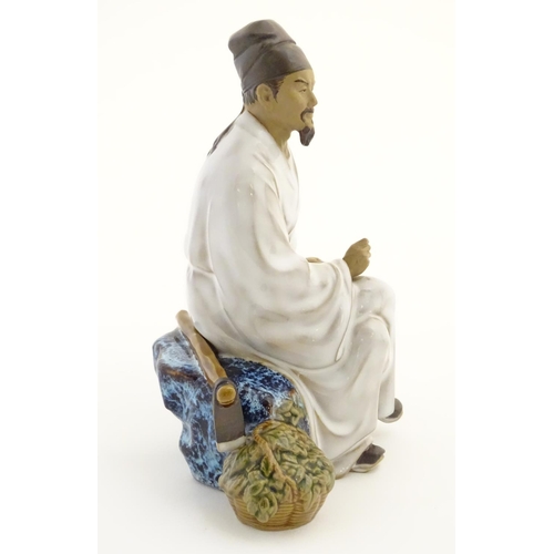 26 - A Chinese partially glazed ceramic mudman figurine depicting a scholar/scribe, thought to be Chung K... 