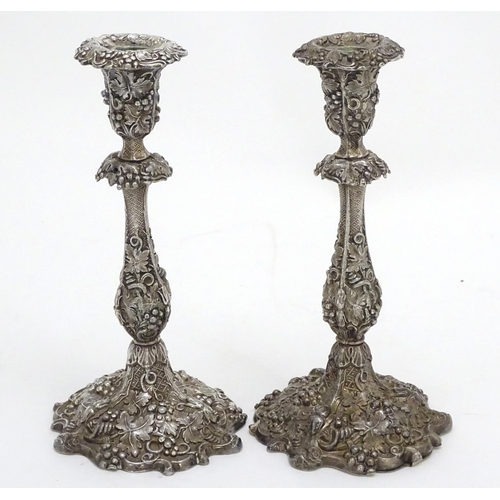 267 - A pair of silver plate candlesticks with profuse fruiting vine decoration. 10 1/4'' high