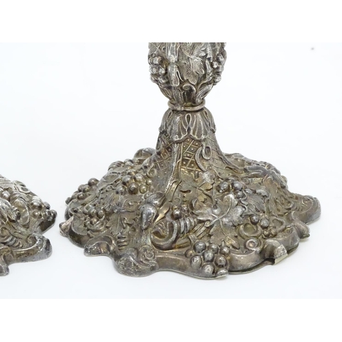 267 - A pair of silver plate candlesticks with profuse fruiting vine decoration. 10 1/4'' high