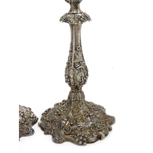 267 - A pair of silver plate candlesticks with profuse fruiting vine decoration. 10 1/4'' high