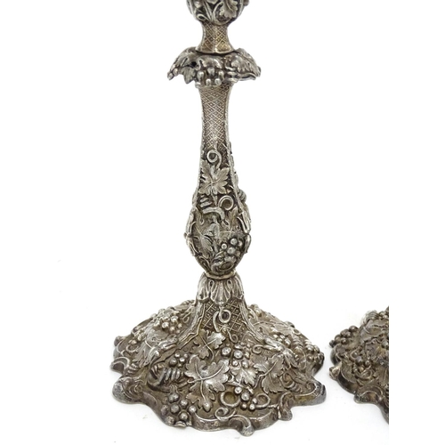 267 - A pair of silver plate candlesticks with profuse fruiting vine decoration. 10 1/4'' high