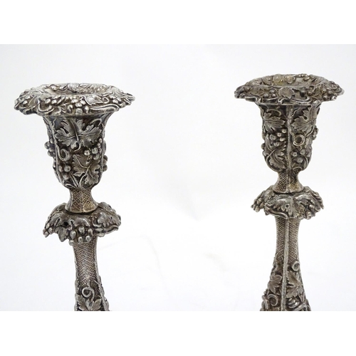 267 - A pair of silver plate candlesticks with profuse fruiting vine decoration. 10 1/4'' high