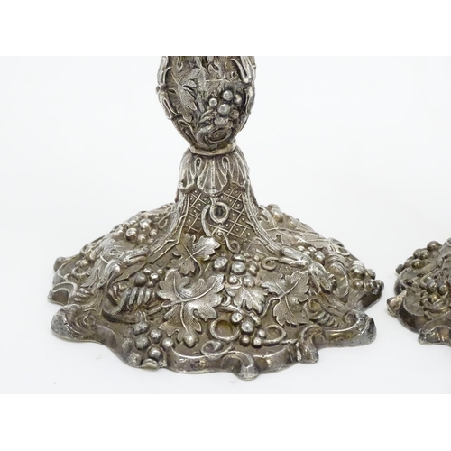 267 - A pair of silver plate candlesticks with profuse fruiting vine decoration. 10 1/4'' high