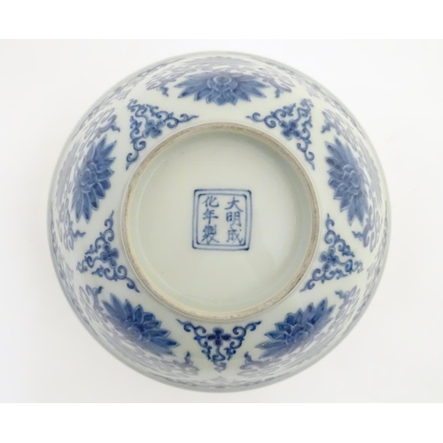 27 - A Chinese blue and white bowl decorated with flowers and scrolling vines. Character marks to base. A... 