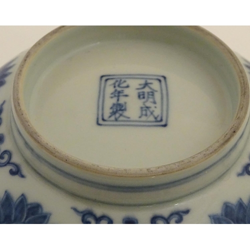 27 - A Chinese blue and white bowl decorated with flowers and scrolling vines. Character marks to base. A... 