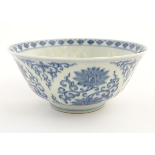 27 - A Chinese blue and white bowl decorated with flowers and scrolling vines. Character marks to base. A... 