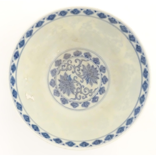 27 - A Chinese blue and white bowl decorated with flowers and scrolling vines. Character marks to base. A... 