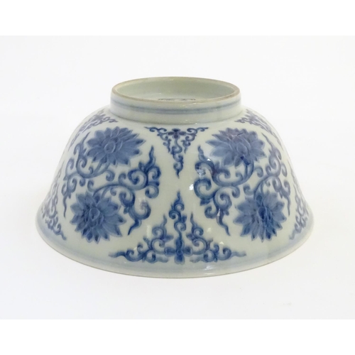 27 - A Chinese blue and white bowl decorated with flowers and scrolling vines. Character marks to base. A... 