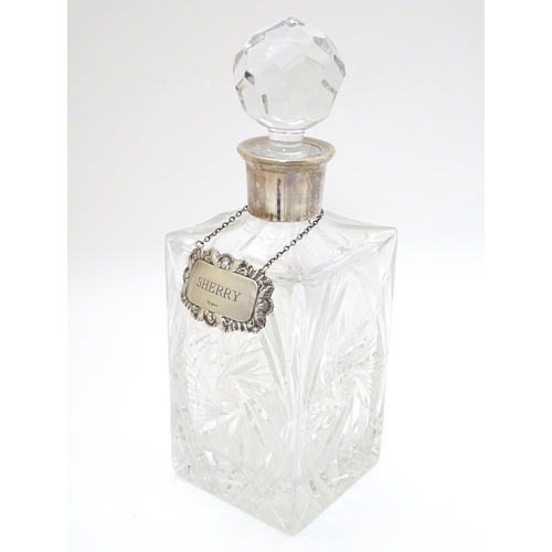 277 - A cut lead crystal decanter of squared form with silver collar and with silver wine label / decanter... 