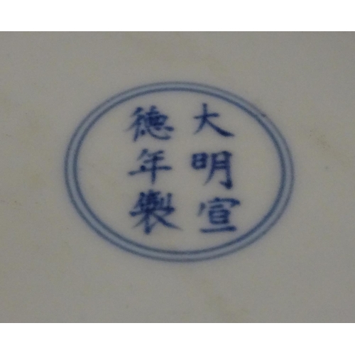 28 - A Chinese blue and white dish decorated with dragons, and scrolling flowers. Character marks to base... 