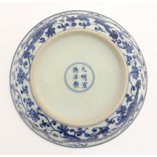 28 - A Chinese blue and white dish decorated with dragons, and scrolling flowers. Character marks to base... 