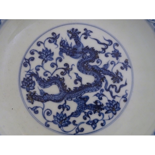 28 - A Chinese blue and white dish decorated with dragons, and scrolling flowers. Character marks to base... 