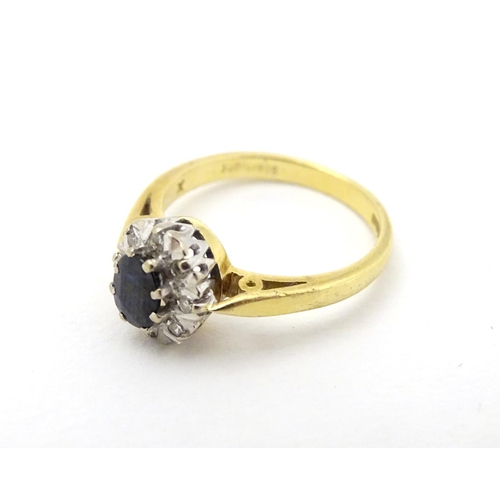 280 - A Vintage 1970's 18ct gold ring set with central sapphire bordered by diamonds