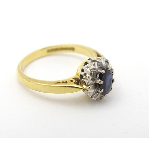 280 - A Vintage 1970's 18ct gold ring set with central sapphire bordered by diamonds