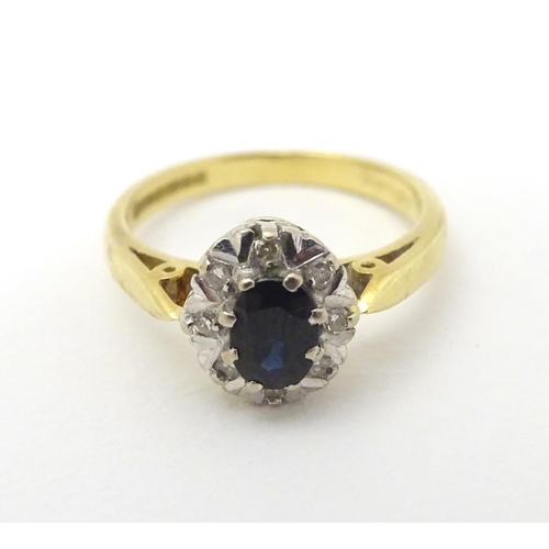 280 - A Vintage 1970's 18ct gold ring set with central sapphire bordered by diamonds