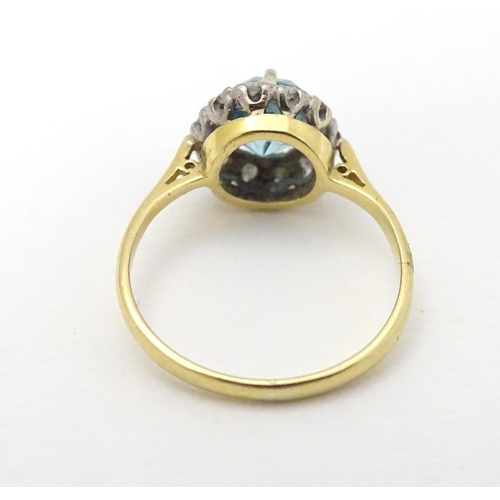 284 - An early - mid 20thC 18ct gold ring set with central blue topaz bordered by diamonds