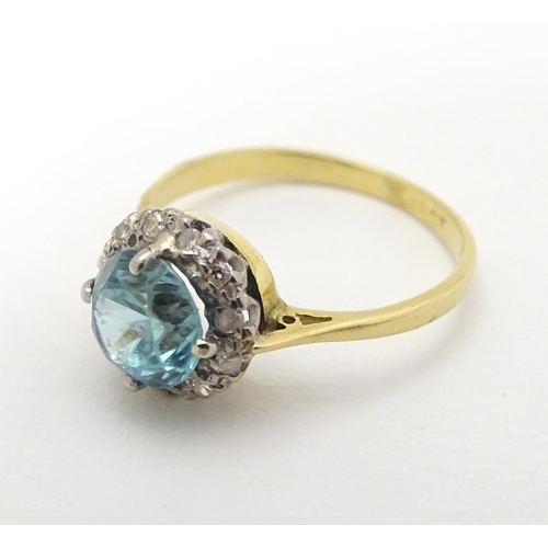 284 - An early - mid 20thC 18ct gold ring set with central blue topaz bordered by diamonds