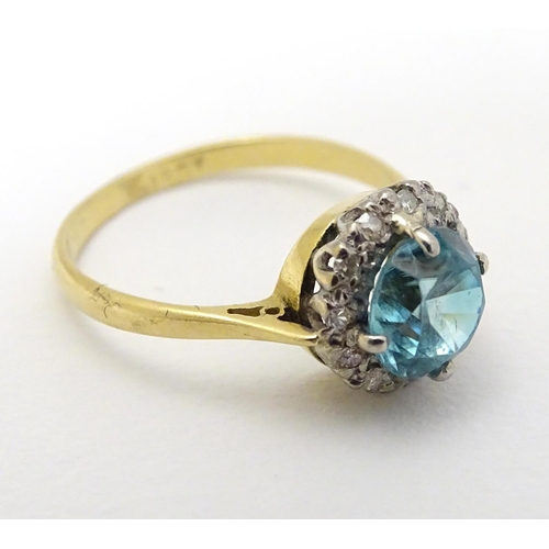 284 - An early - mid 20thC 18ct gold ring set with central blue topaz bordered by diamonds