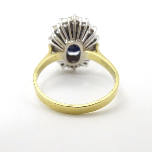 288 - A vintage 18ct gold ring set with central sapphire bordered by 14 diamonds. The setting approx 3/4''... 