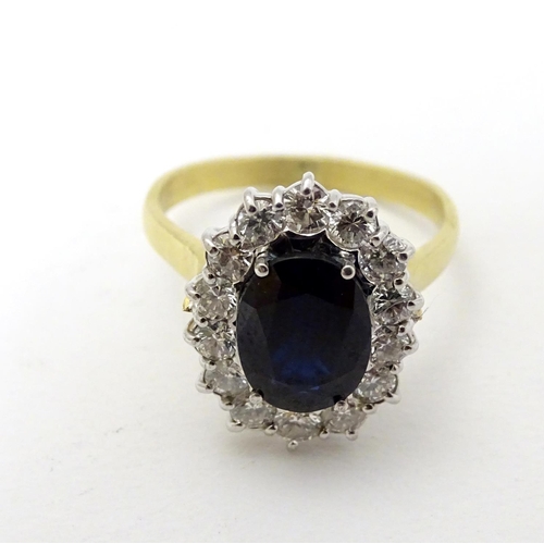 288 - A vintage 18ct gold ring set with central sapphire bordered by 14 diamonds. The setting approx 3/4''... 