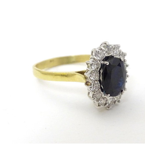 288 - A vintage 18ct gold ring set with central sapphire bordered by 14 diamonds. The setting approx 3/4''... 