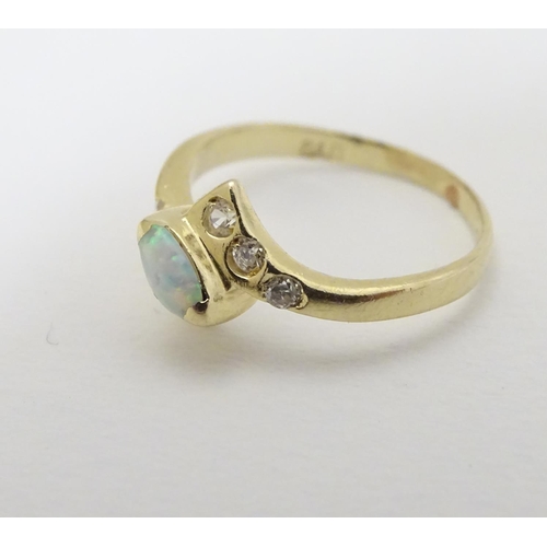 289 - An opal ring set with central opal flaked by white stones. Marked 14k