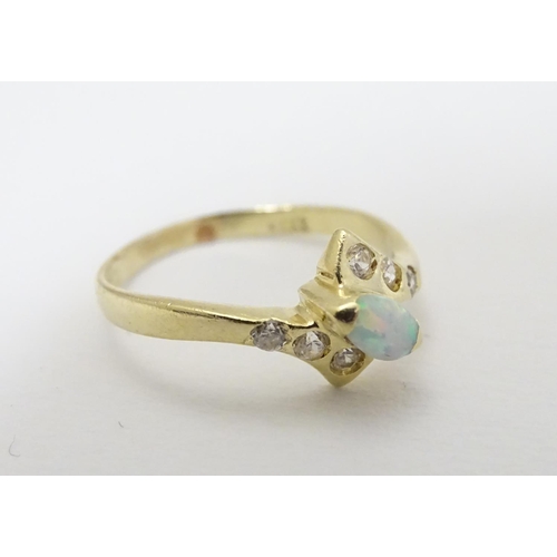 289 - An opal ring set with central opal flaked by white stones. Marked 14k