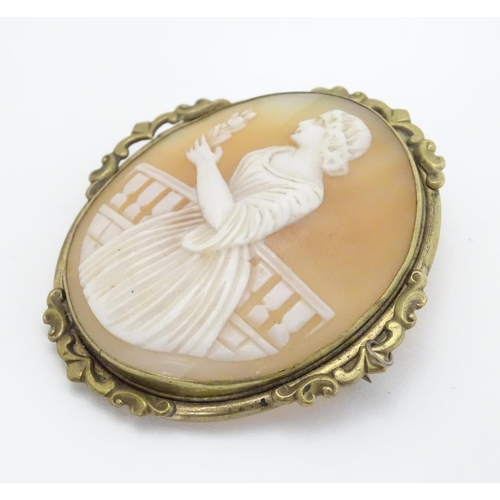 296 - A 19thC shell carved cameo brooch depicting a lady on  a terrace holding a flower. In gilt metal mou... 