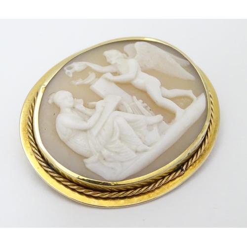 297 - A Victorian shell carved cameo brooch depicting classical scene with Cupid like cherub and a muse,  ... 