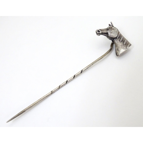 301 - A white metal stick pin surmounted by a horses head. Approx 3'' long overall